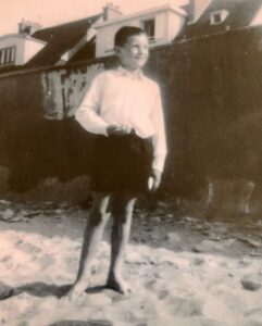 Florent Chopin enfant (10 ans), les pieds dans le sable d'une plage de Normandie